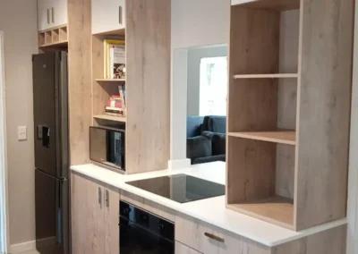 A beautiful light timber kitchen paired with off white cabinet door details and muted white stone counter tops
