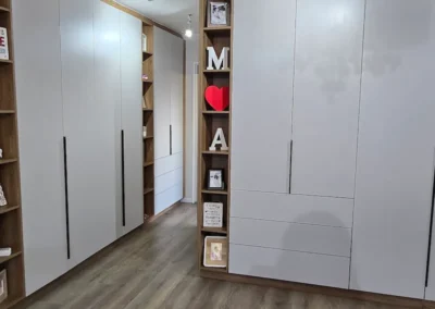 An architecturally thought out walk in closet with muted grey fascia tones and warm timber elements.