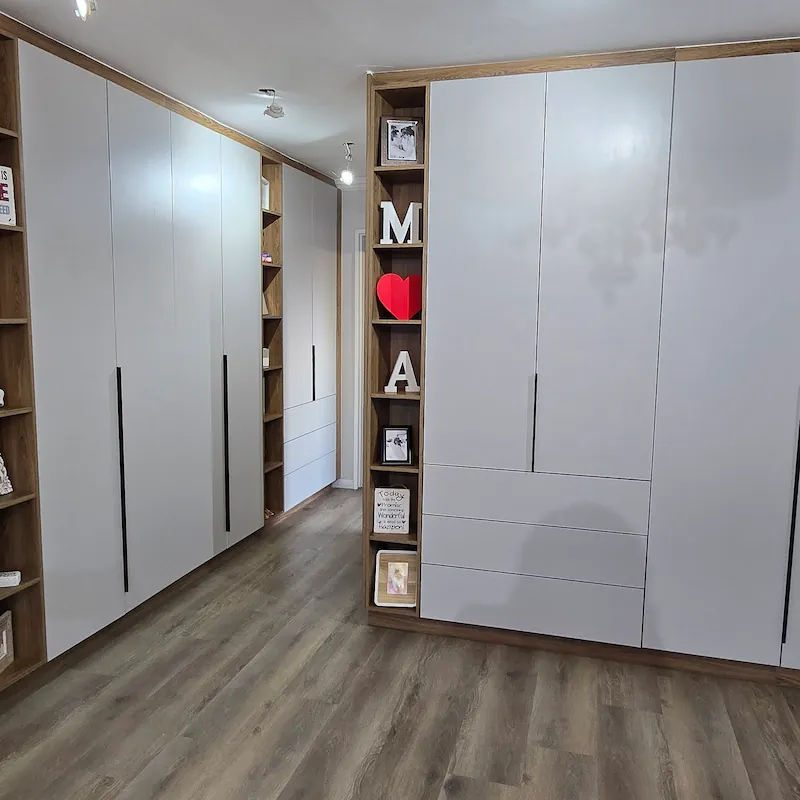 An architecturally thought out walk in closet with muted grey fascia tones and warm timber elements.