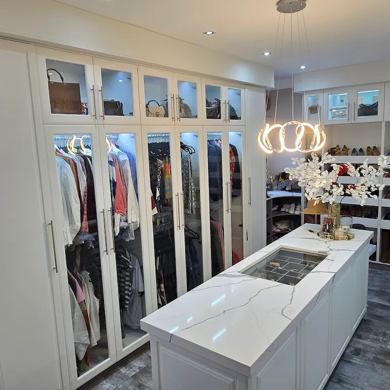 A crisp clean, white and glass detail walk in closet for the those with the finest of tastes