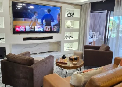 This luxurious and bold built in TV unit as a centre piece to the room with brilliant white LED lighting and built in fire place