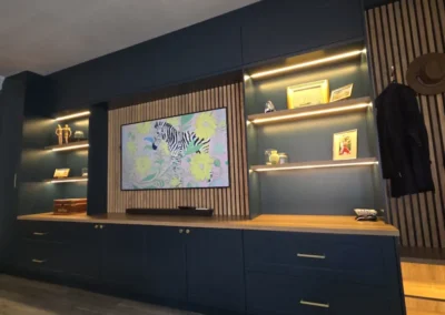 A bold and calming TV unit with warm white LED lighting detail and midnight blue cabinets