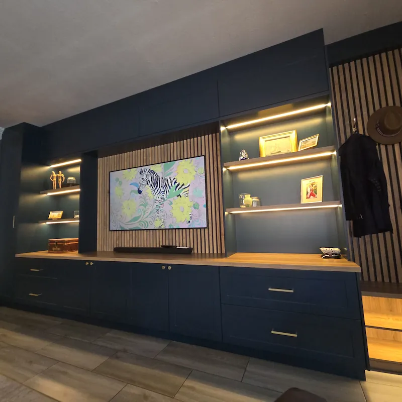 A bold and calming TV unit with warm white LED lighting detail and midnight blue cabinets