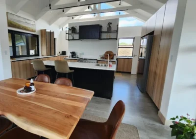 A spacious yet functional kitchen with contrasts of warm timber finishes and black industrial elements.