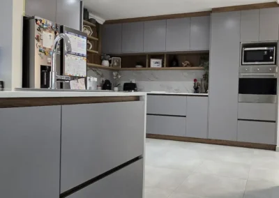 A modern kitchen with light grey cabinets and handle less design