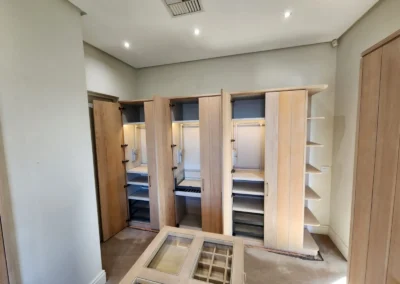 Open custom wardrobes with hanging sections, internal lighting, pull-out storage and central island display drawers