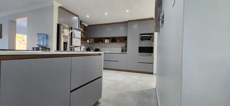 Fitted Kitchen Cupboards Johannesburg Grey and Timber Finish Fitted kitchen cupboards in Johannesburg with grey cabinetry, timber accents, integrated appliances and practical storage planning