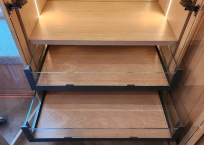Illuminated walk-in closet shelving with glass-front pull-out storage and warm timber cabinetry