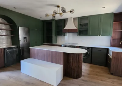 Luxury Bedfordview kitchen with green cabinetry, timber island, curved slatted detail and contemporary brass accents