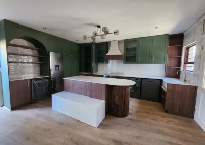 Luxury kitchen project in Bedfordview featuring green cabinetry, curved island detail, timber accents and brass hardware
