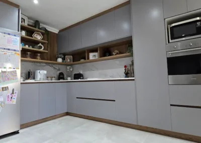 Modern family kitchen in Modderfontein with grey cabinetry, timber accents, integrated oven, microwave, open shelves and stone-look splashback